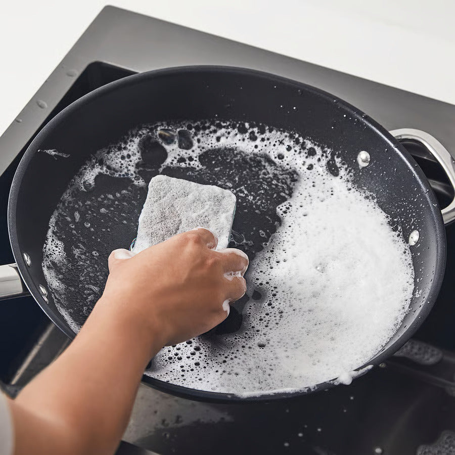 Using spongue to clean the dishes 