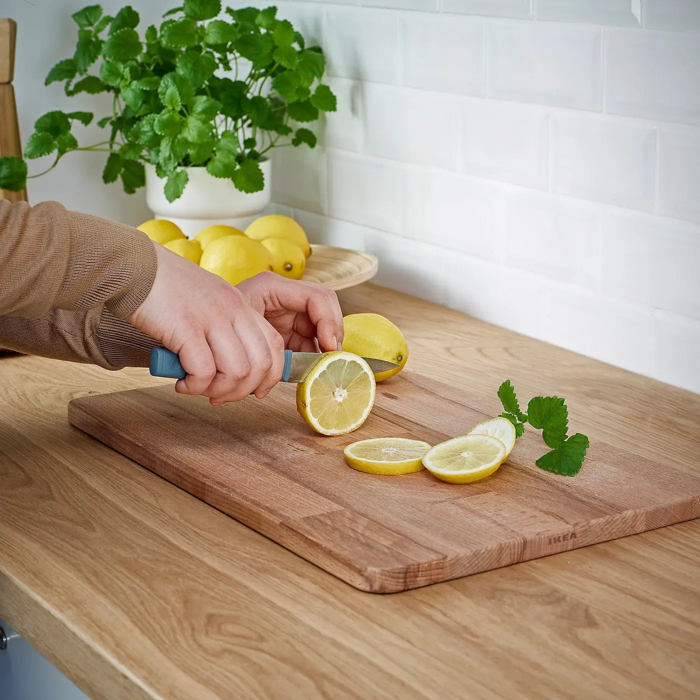 Using small kitchen knife to cut a lemon and doing that work easily