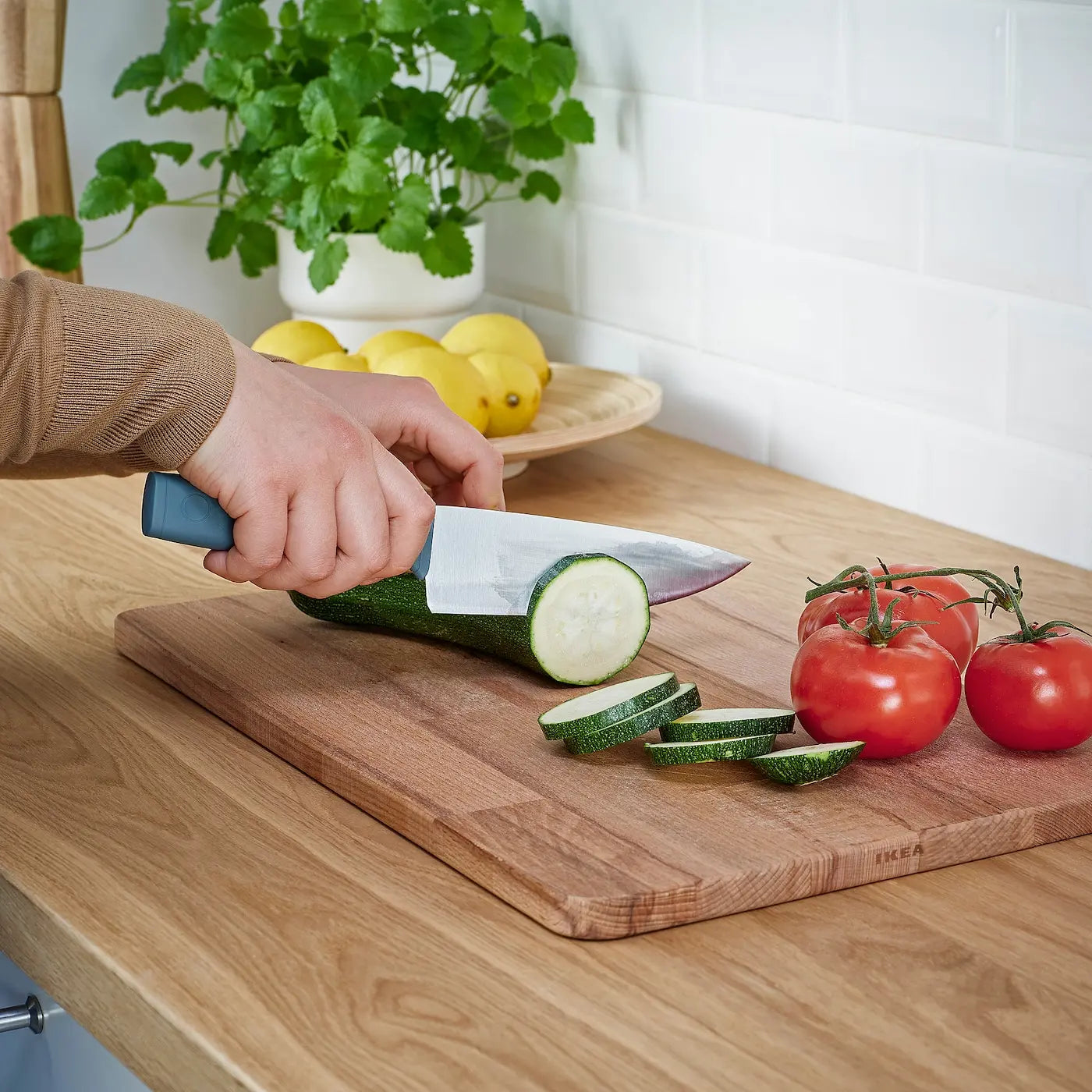 Using medium kitchen knife to cut a  vegetables and doing that work easily